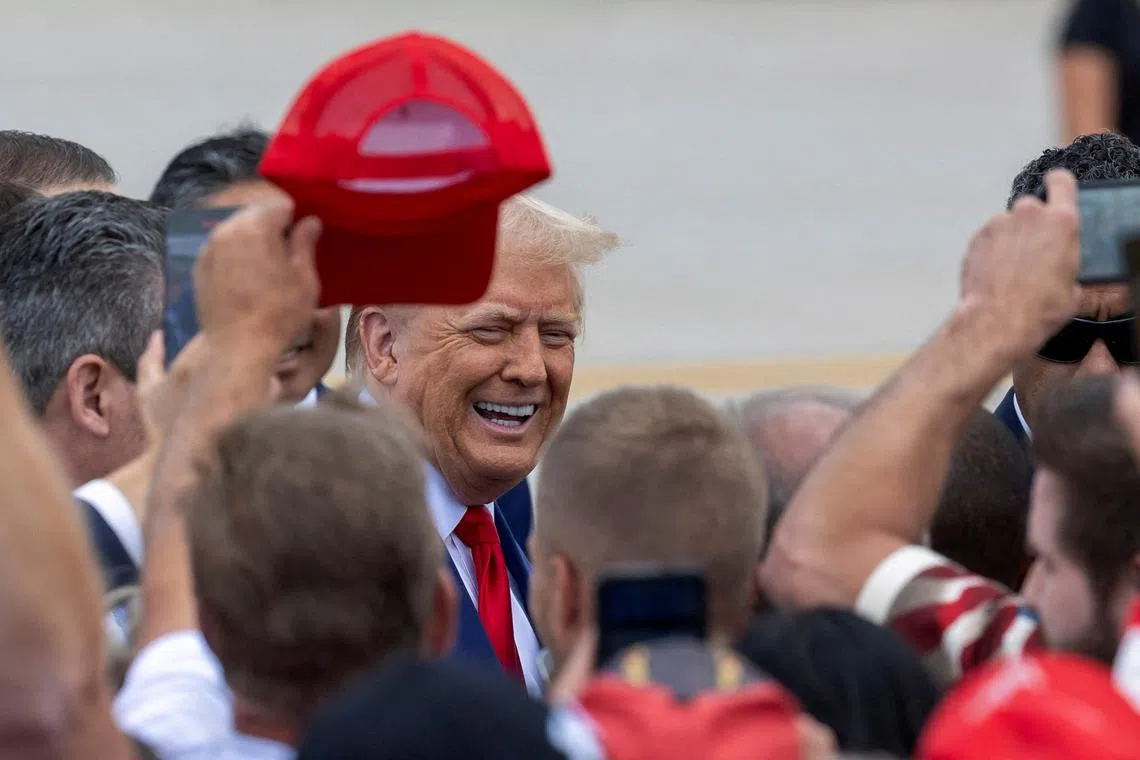 Republican presidential candidate and former U.S. President Donald Trump greets supporters on the tarmac at Wayne County Airport in Romulus, Michigan, U.S. August 20, 2024.  REUTERS/Rena Laverty