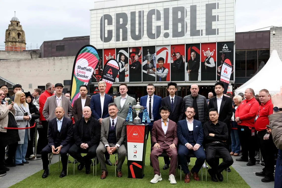(Back row from left to R) England's Chris Wakelin, China's Xiao Guodong, Australia's Neil Robertson, England's Shaun Murphy, England's Mark Selby, China's Wu Yize, Wales' Mark Williams and China's Si Jiahui (front row from left) England's Barry Hawkins, Scotland's John Higgins, England's Kyren Wilson, China's Zhao Xintong, Northern Ireland's Mark Allen and China's Ding Junhui taking a photo with the trophy during a media day launching the start of the World Snooker Championship at Crucible Theatre in Sheffield, northern England, on April 17, 2026.