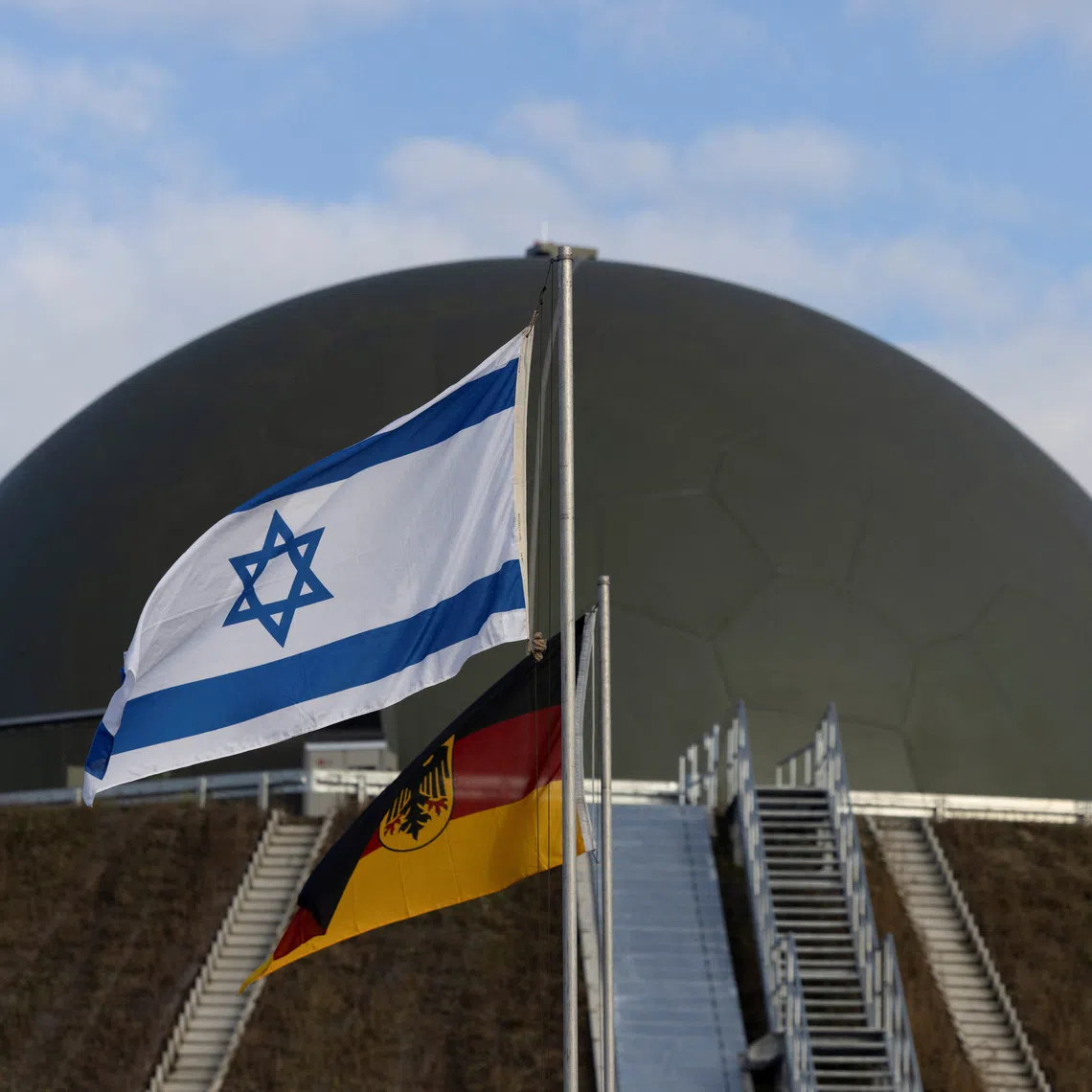 Flags flutter in front of a radom of the \"Arrow Weapon System for Germany\" pictured in Annaburg, Germany, December 3, 2025. REUTERS/Axel Schmidt