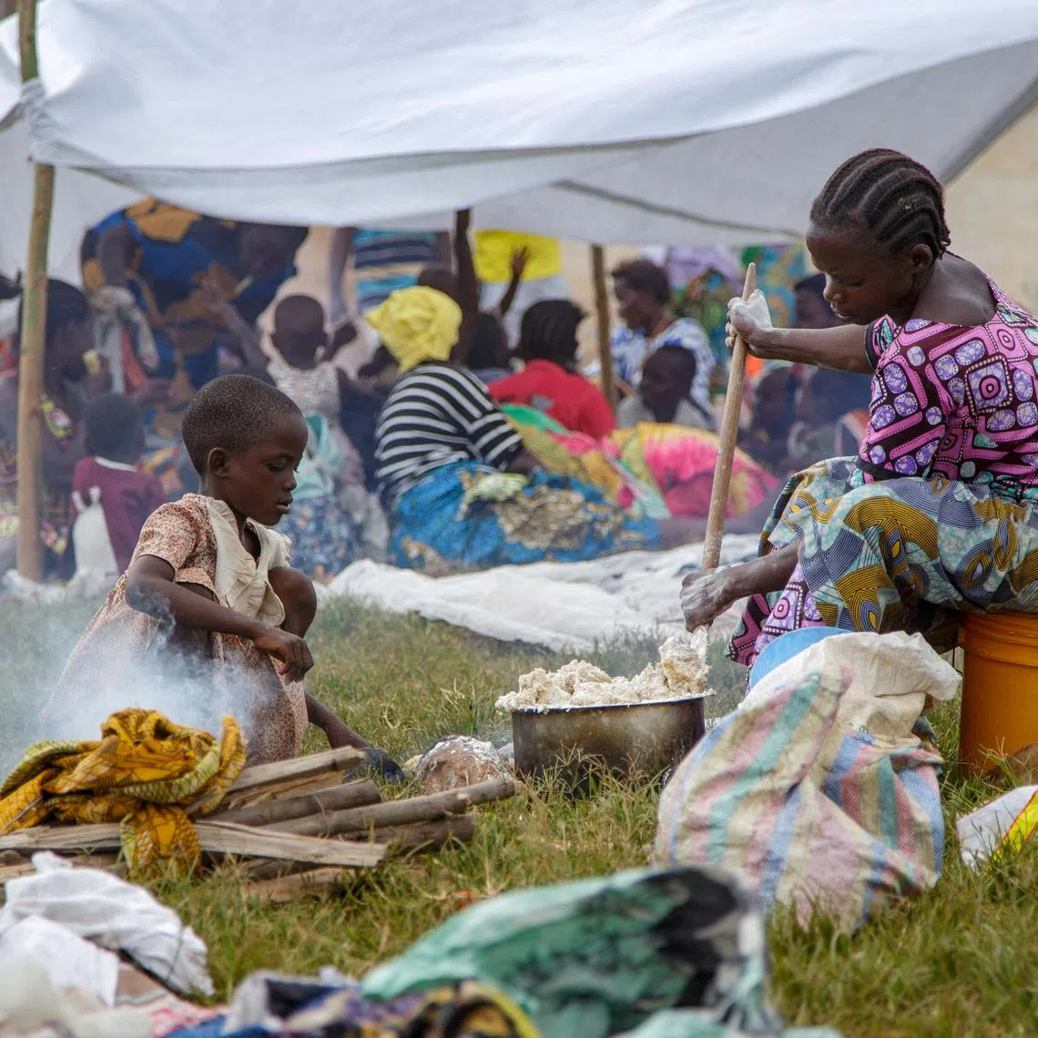 FILE PHOTO: A Congolese woman prepares a meal near a temporary shelter at Rugombo Stadium, after fleeing from renewed clashes between M23 rebels and the Armed Forces of the Democratic Republic of the Congo (FARDC), in Rugombo commune of Cibitoke Province, Burundi February 18, 2025. REUTERS/Evrard Ngendakumana/File Photo