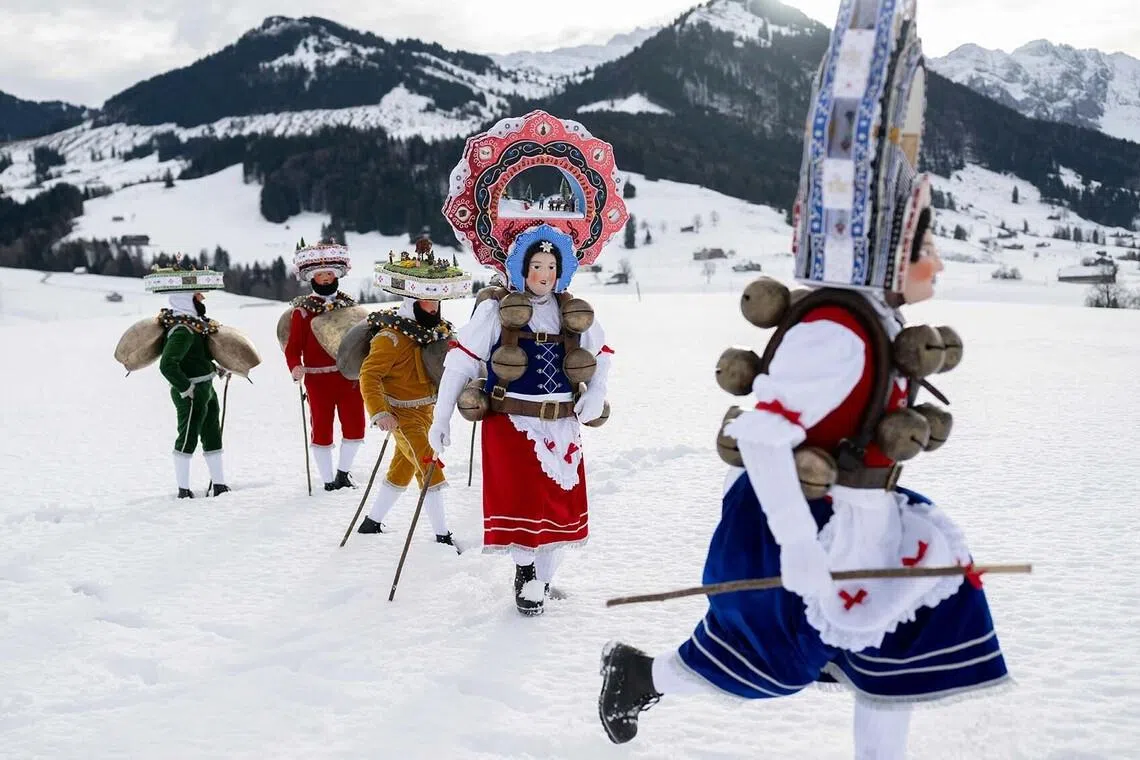 'Schoene' (Beautiful) costumed members of the yodel group 'Spitzli Schueppel' take part in the traditional 'Silvesterchlausen' (Saint Sylvester’s Day festivities) in Urnasch, eastern Switzerland, on January 13, 2026. Silvesterchlausen a traditional custom from the Swiss canton of Appenzell, features colorfully dressed figures organized in groups called 'Schuppel' who symbolically chase away the old year and welcome the new one by traveling from farmstead to farmstead to sing yodels and greet farmers. The tradition take place twice a year: on December 31 for the “New Silvester,” and again on January 13, following the old Julian calendar. (Photo by ENNIO LEANZA / AFP)