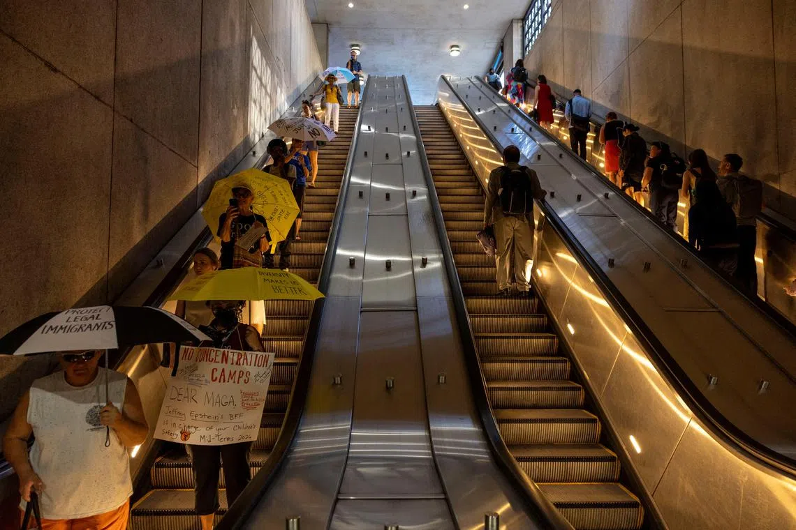 Demonstrators entering a train station with their umbrellas during a "Good Trouble Umbrella Protest" against U.S. President Donald Trump and in remembrance of late U.S. Congressman and civil rights pioneer John Lewis, in Washington, DC, US, on July 17, 2025. 