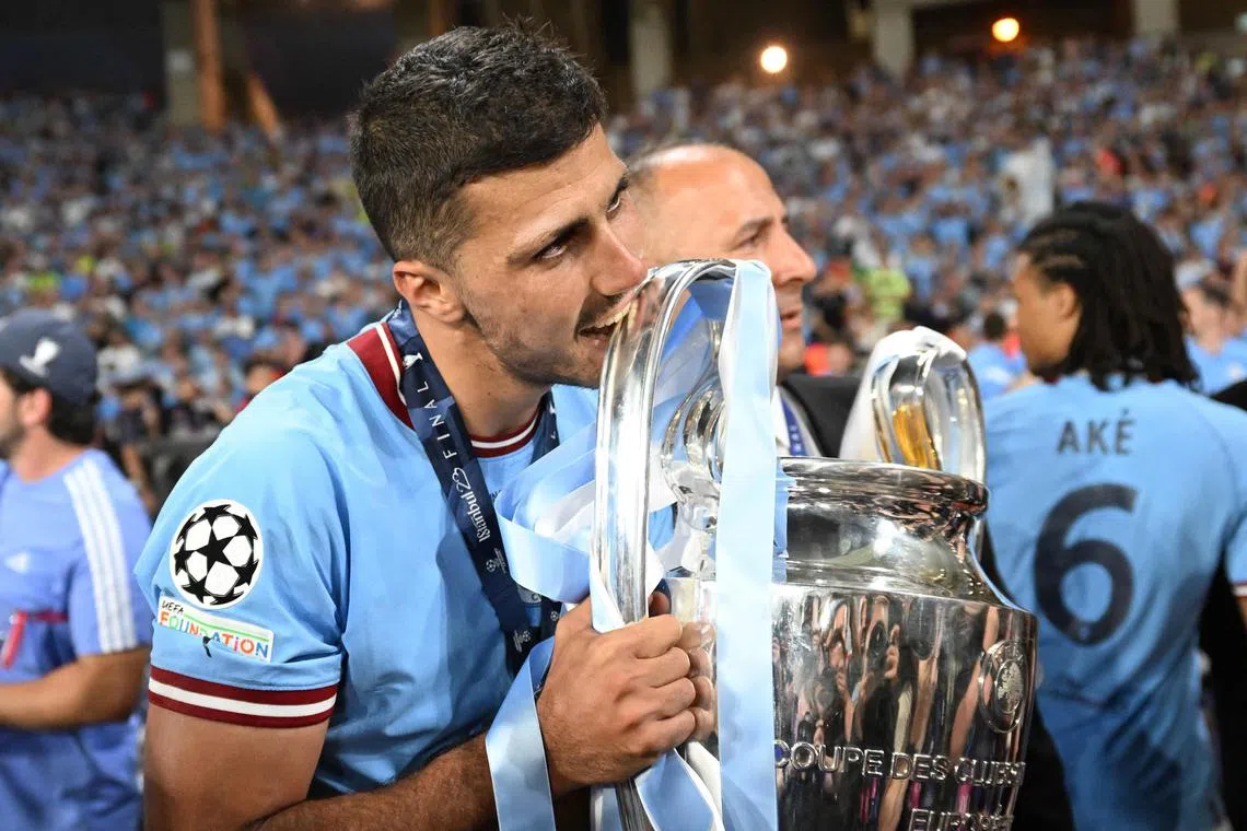 Manchester City's Spanish midfielder Rodri celebrates with the European Cup trophy.