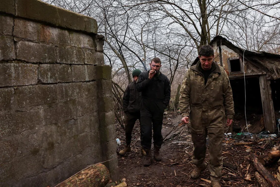 Ukrainian tank crew members emerge from a bunker after taking cover from shelling, near the bombed-out eastern Ukrainian city of Bakhmut, on March 29, 2023.