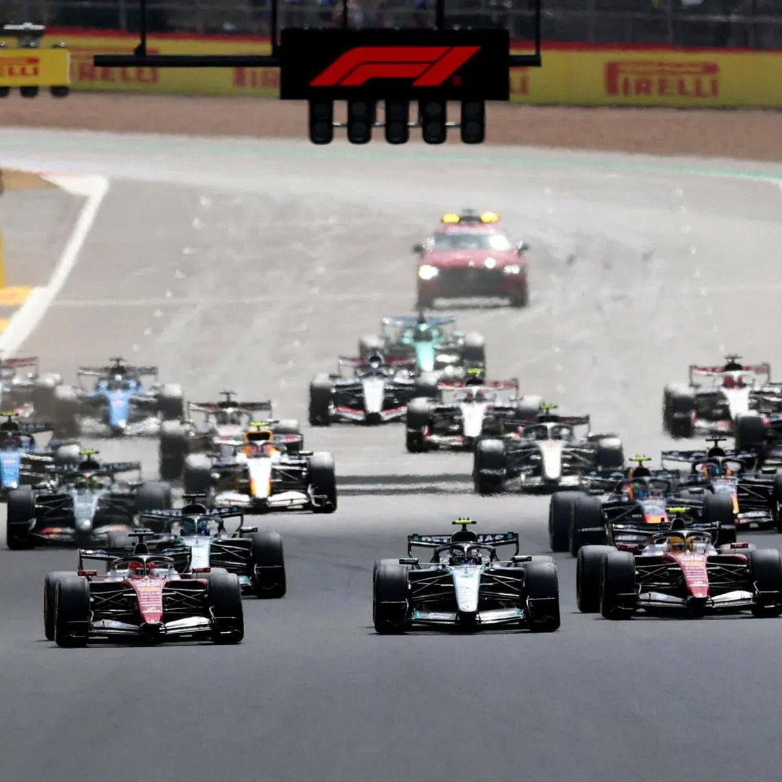 Formula One F1 - British Grand Prix - Silverstone Circuit, Silverstone, Britain - July 5, 2026 Ferrari's Charles Leclerc leads into the first corner at the start of the race ahead of Ferrari's Lewis Hamilton and Mercedes' Andrea Kimi Antonelli REUTERS/Andrew Boyers