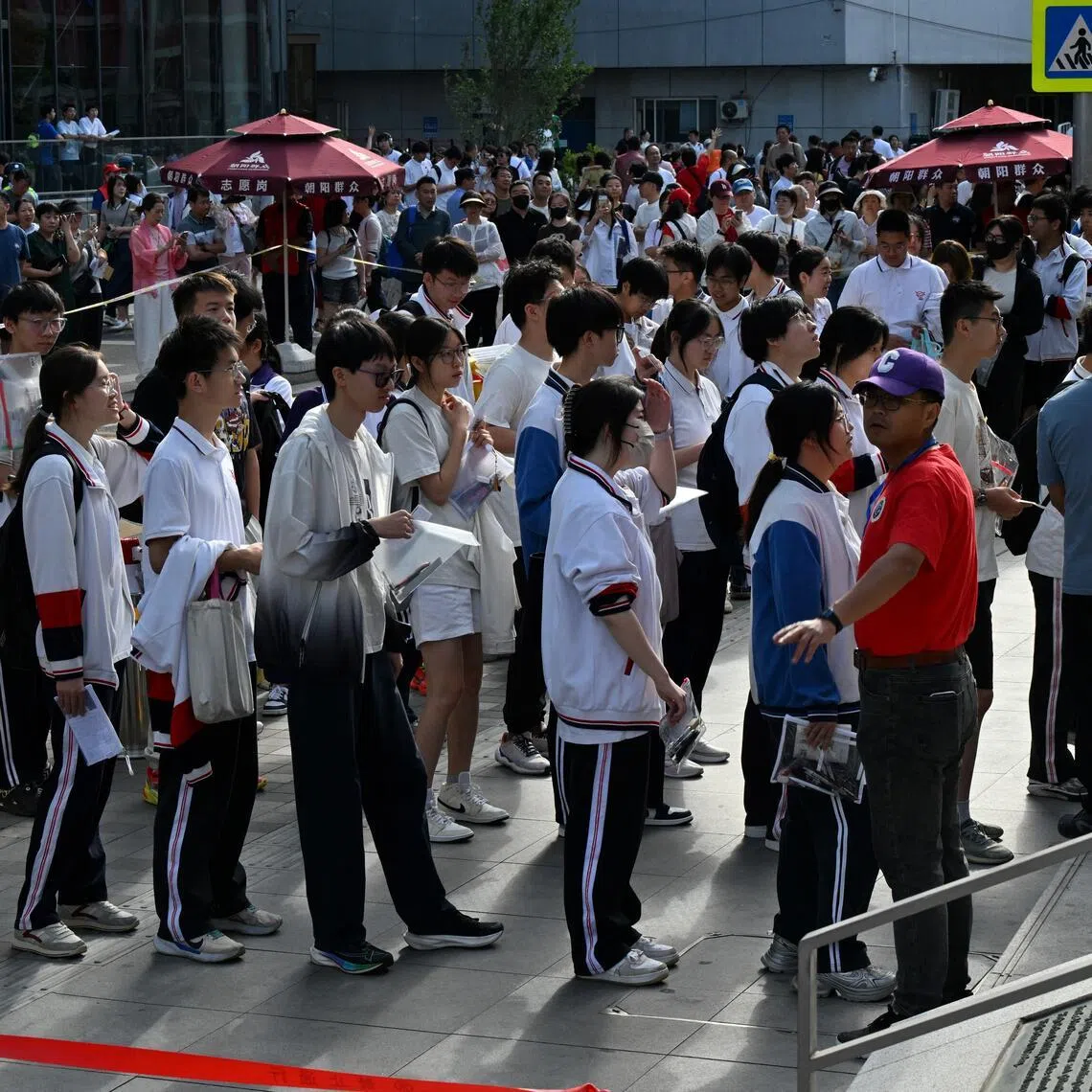 Students queue to enter a school during China's national college entrance exam, known as gaokao, outside a high school in Beijing on June 7, 2025.