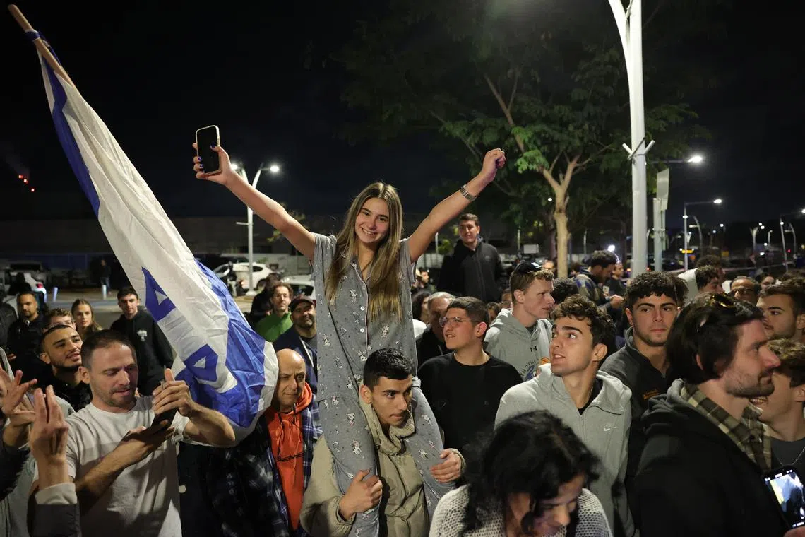 People gather to watch the military helicopter carrying three Israeli female hostages land at Sheba Medical Center in Ramat Gan, Israel, Jan 19, 2025. 
