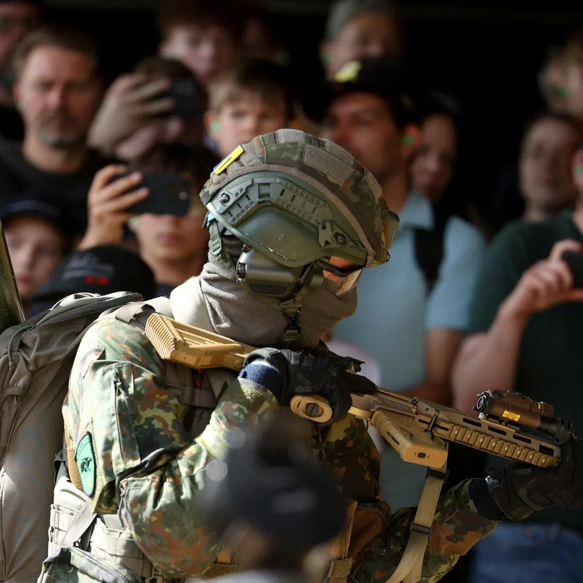 Visitors watch as an armed soldier conducts a demonstration during the "Tag der Bundeswehr", as the German armed forces Bundeswehr open their doors to the public, in Unna, Germany, June 6, 2026. REUTERS/Leon Kuegeler