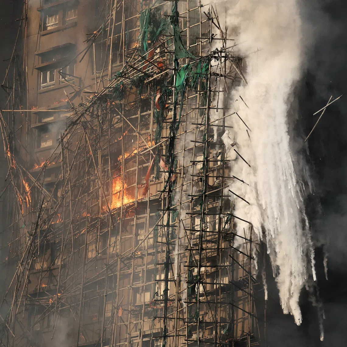 FILE PHOTO: Smoke rises while flames burn bamboo scaffolding on a building at Wang Fuk Court housing complex during a deadly fire in Tai Po, Hong Kong, China, November 26, 2025. REUTERS/Tyrone Siu/File Photo