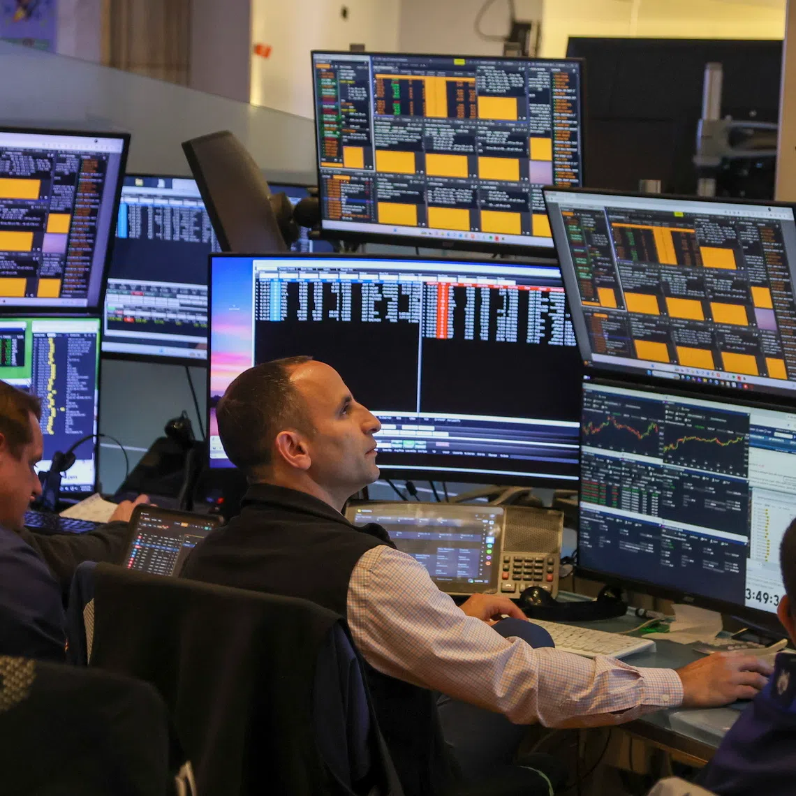 Traders work on the floor of the New York Stock Exchange before the closing bell in New York City, on Oct 6.