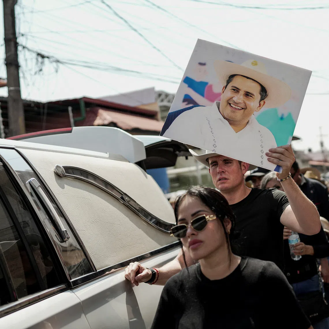 A person holds a picture of Carlos Manzo, the mayor who was shot dead during a Day of the Dead event, in Uruapan, Mexico, November 2, 2025. REUTERS/Ivan Arias