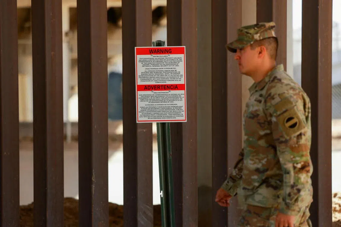 A soldier walks past a warning sign marking a restricted area near the U.S.-Mexico border, as part of the Trump administration’s crackdown on immigration and following the establishment of a 260-mile military zone along the U.S. southern border in New Mexico and Texas, in El Paso, Texas, U.S., May 22, 2025. REUTERS/Jose Luis Gonzalez