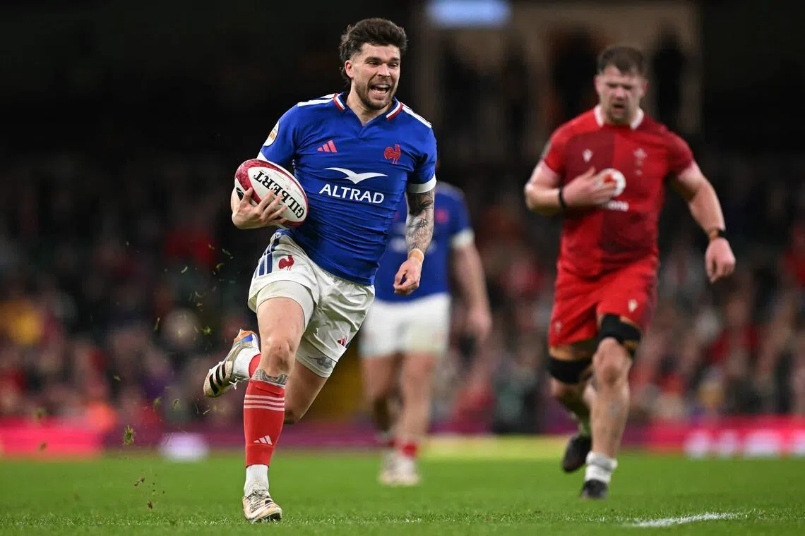 France's fly-half Matthieu Jalibert runs in a try during the Six Nations match against Wales at the Principality Stadium in Cardiff.