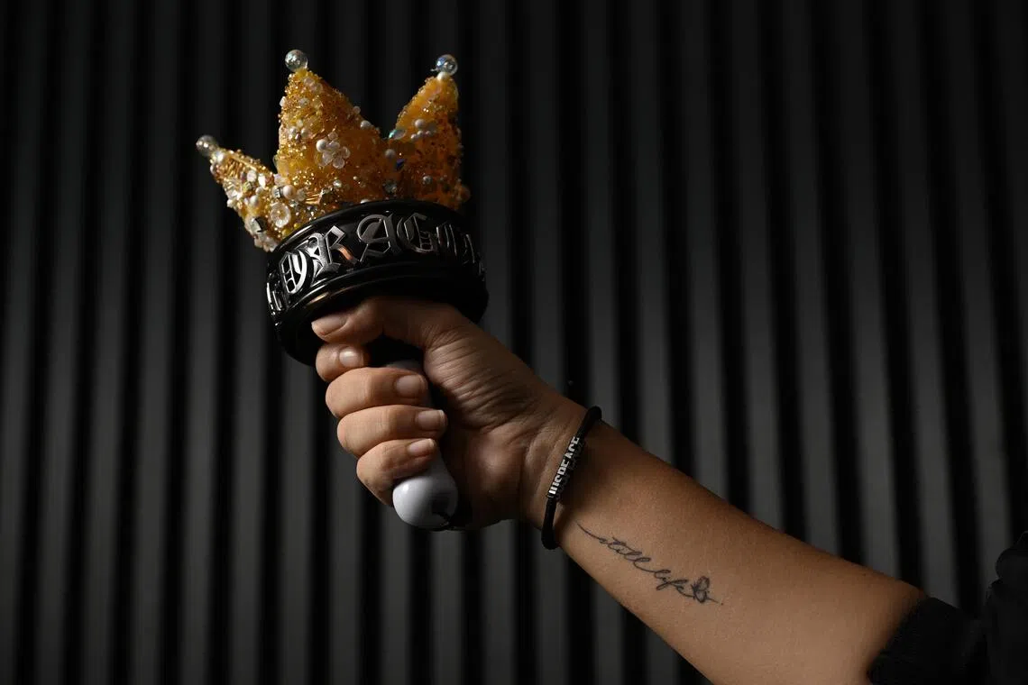 Priscilla Koh with her personalised Bang Bong, the official concert lightstick of BigBang. She also has a tattoo on her wrist of the words Still Life, the title of BigBang’s 2022 single about bidding farewell to youth.