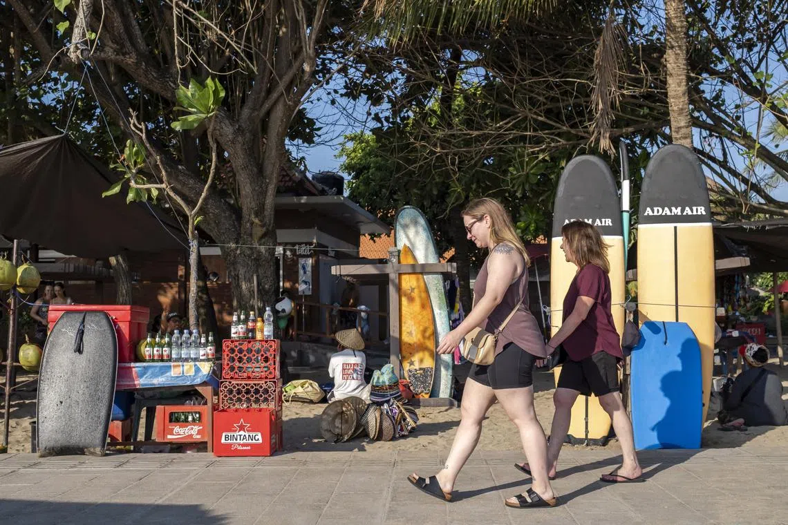 epa10645529 Foreign tourists walk at a beach in Kuta, Bali, Indonesia, 22 May 2023. The Bali Tourism Office recorded foreign tourist visits to Bali in the first quarter of 2023 reaching 1.4 million people. The Provincial Government of Bali is optimistic that the target of 4.5 million foreign tourist visits in 2023 will be achieved.  EPA-EFE/MADE NAGI