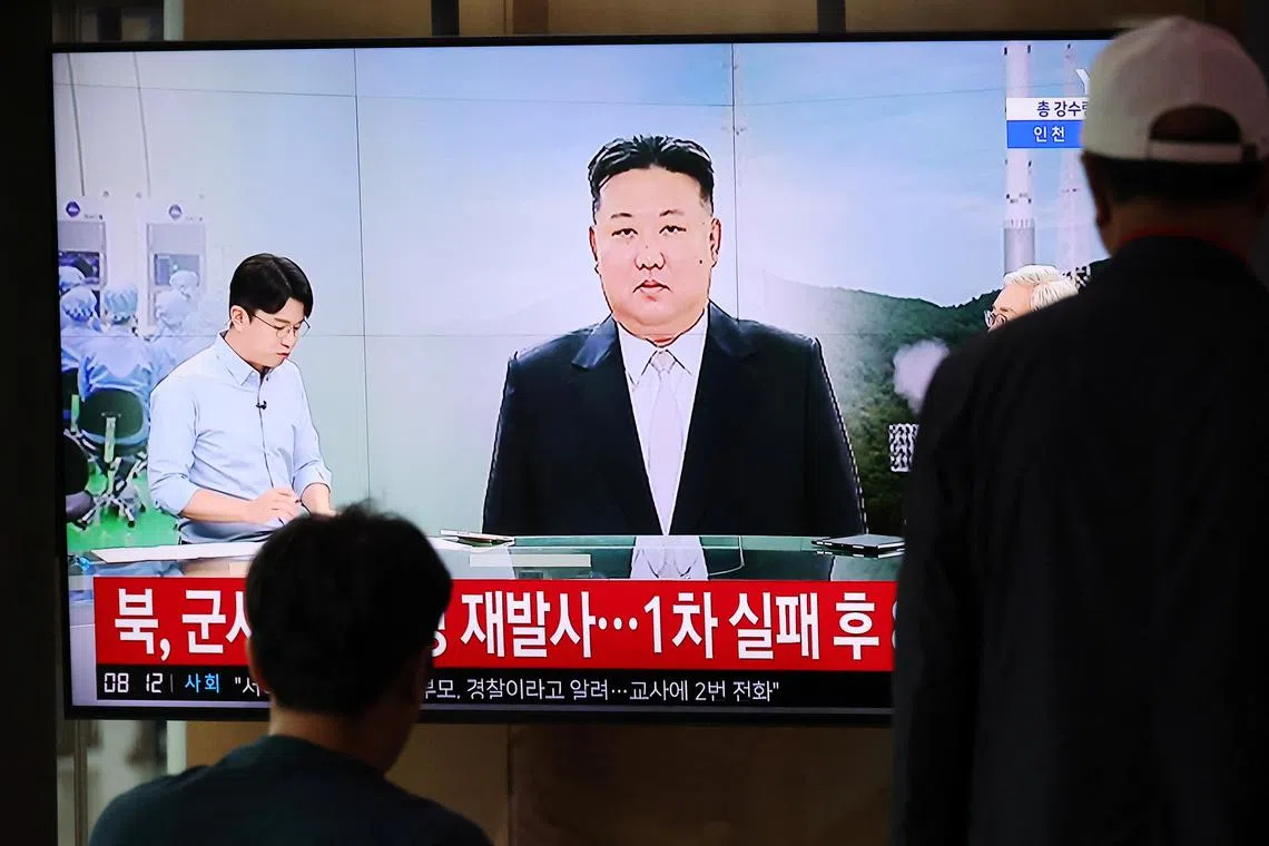 Passengers watch a TV broadcasting a news report on North Korea firing a space rocket, at a railway station in Seoul, South Korea, August 24, 2023.    REUTERS/Kim Hong-Ji