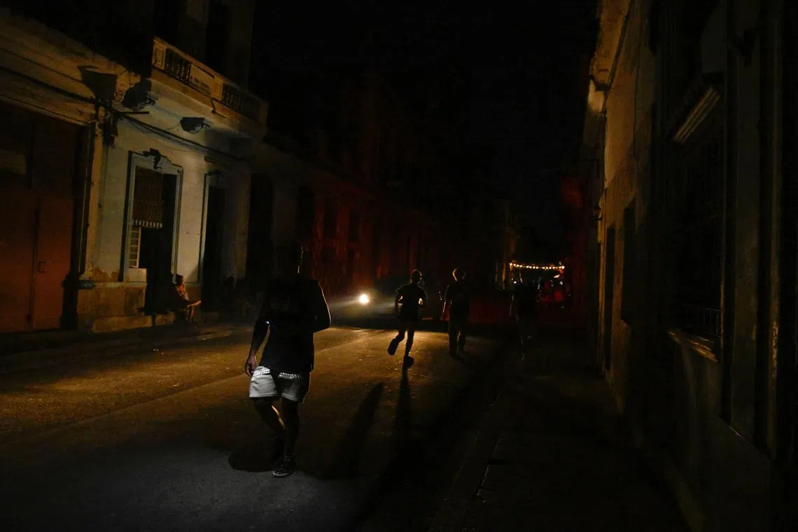People walk on the street during a national power grid collapse, the fourth in less than a year, which caused a nationwide blackout, in Havana, Cuba September 10, 2025. REUTERS/Norlys Perez