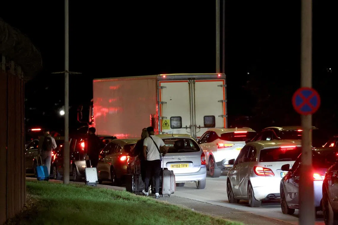 Passengers walking back to Heathrow's reopened Terminal 4 on Sept 8, after emergency services responded to what they called a "possible hazardous materials incident".
