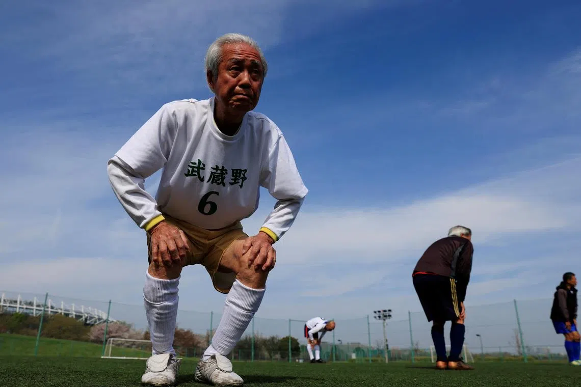 Mutsuhiko Nomura, 83, stretches during a practice. He is a member of the brand new over-80 division of Tokyo's "Soccer For Life" league. 