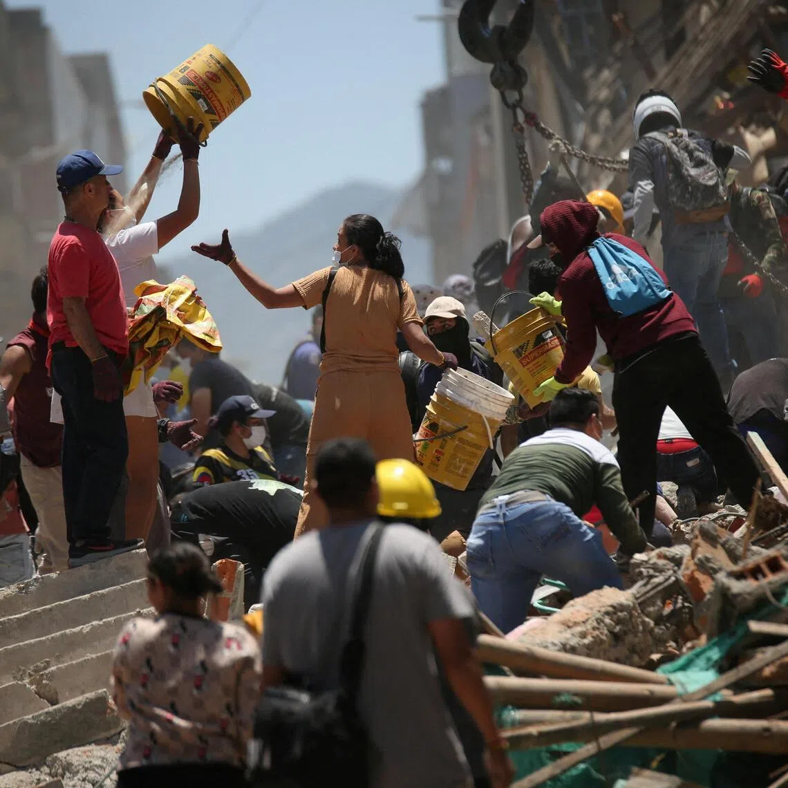 People shifting rubble at the site of a damaged building in Pereira, Colombia, on Aug 11.