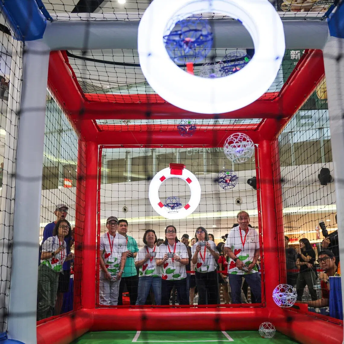 Seniors from PCF Sparkle Care Active Ageing Centre (Care) @ Eunos (in photo) play against seniors from THK Active Ageing Centres@Toa Payoh during a drone soccer tournament final at Compass One on Aug 1.