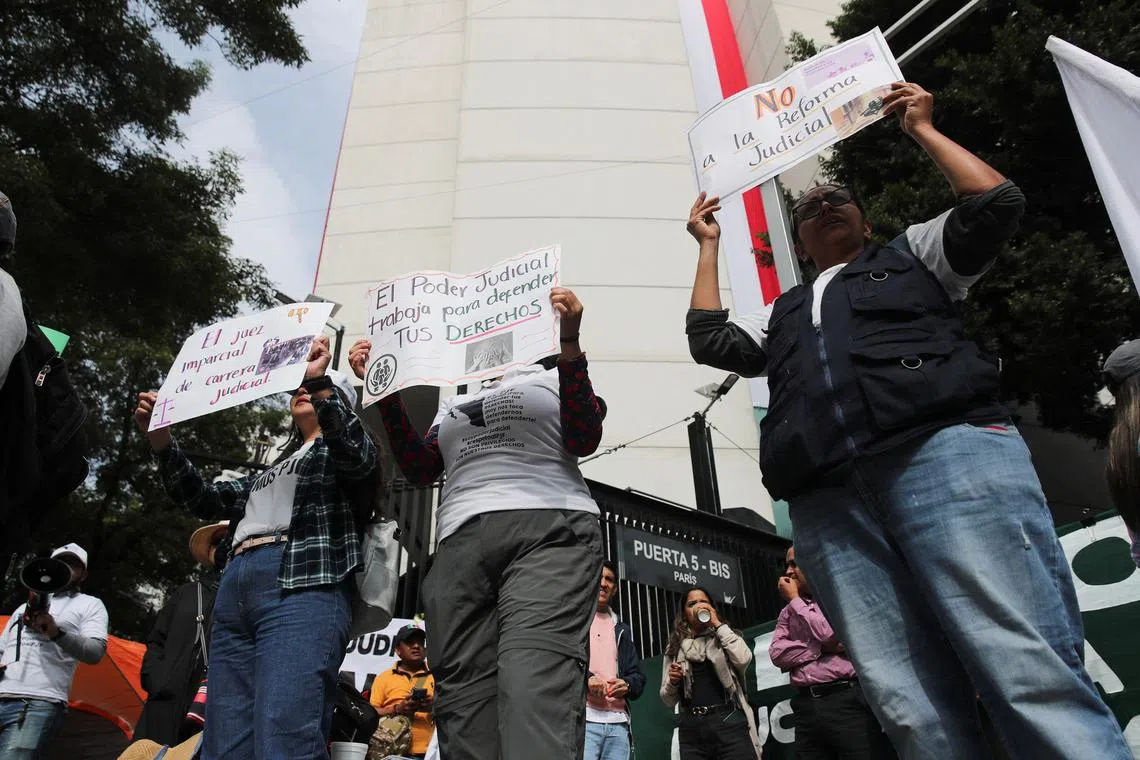 FILE PHOTO: People hold signs reading \"The impartial judge with a judicial career\", \"The judiciary works to defend your rights\" and \"No to the judicial reform\" during a protest against the controversial overhaul of the country's judiciary, which would usher in a new era of elections for all judges, outside the Senate building in Mexico City, Mexico September 5, 2024. REUTERS/Henry Romero/File Photo