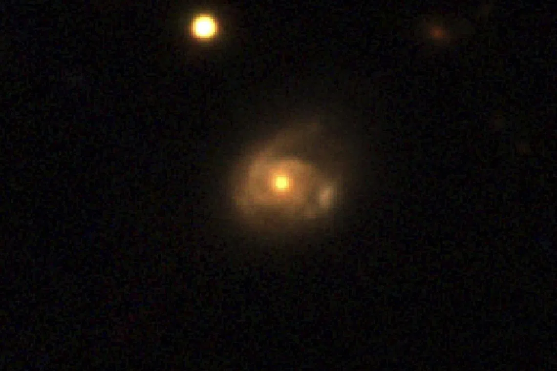 The interaction between a supermassive black hole in a galaxy named 2MASX J02301709+2836050 and a star orbiting it is seen in this image captured by the Pan-STARRS telescope, in Hawaii, U.S., in an undated handout image provided by NASA. Neils Bohr Institute/Daniele Malesani/Handout via REUTERS    THIS IMAGE HAS BEEN SUPPLIED BY A THIRD PARTY. 