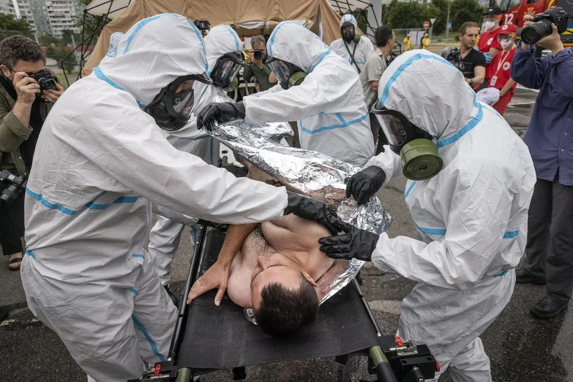 A man on a stretcher was brought into a medical tent as sirens blared, as part of the drills.