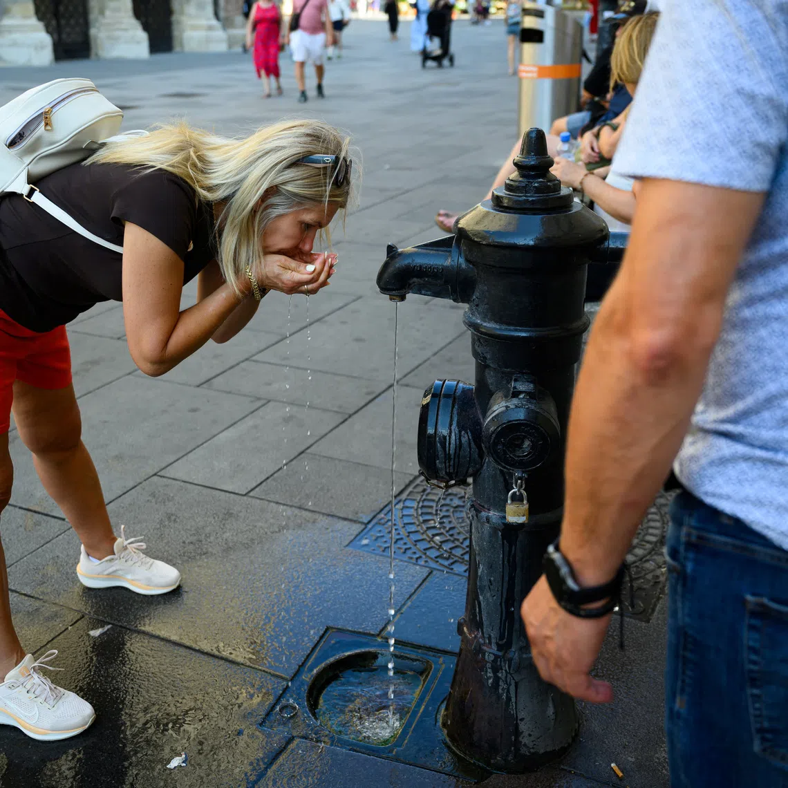 A person drinks at a public fountain near St. Stephen’s Cathedral during a heatwave in Vienna, Austria, August 3, 2026. REUTERS/Elisabeth Mandl