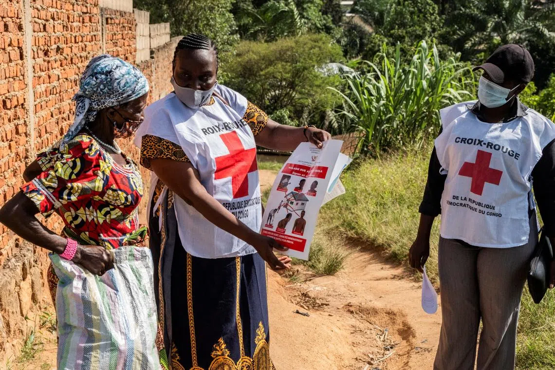 FILE PHOTO: Red Cross outreach workers talk to a woman in a residential area, to raise awareness about Ebola, as aid agencies intensify efforts to contain an Ebola outbreak caused by the Bundibugyo virus in Bunia, Democratic Republic of Congo, May 25, 2026. REUTERS/Stringer/File Photo