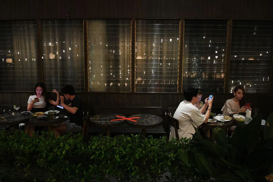 People spend their time inside a bar after the Thai government eased isolation measures and introduced social distancing to prevent the spread of Covid-19 on July 1, 2020. REUTERS/Chalinee Thirasupa/File photo