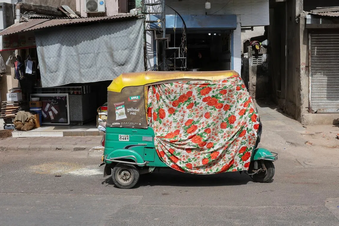 An autorickshaw covered with a cloth is seen on the street during a heat wave in Ahmedabad, India, May 30, 2024. REUTERS/Amit Dave
