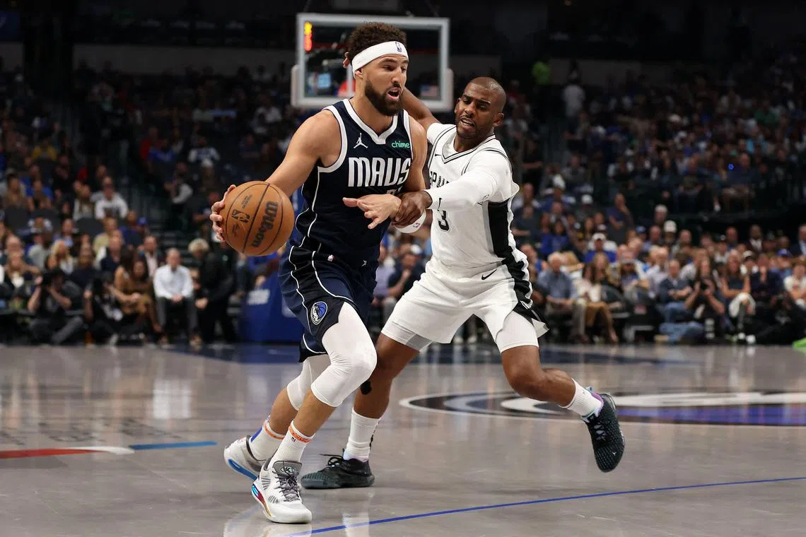Klay Thompson of the Dallas Mavericks is defended by Chris Paul of the San Antonio Spurs during the first quarter of the game at American Airlines Centre.