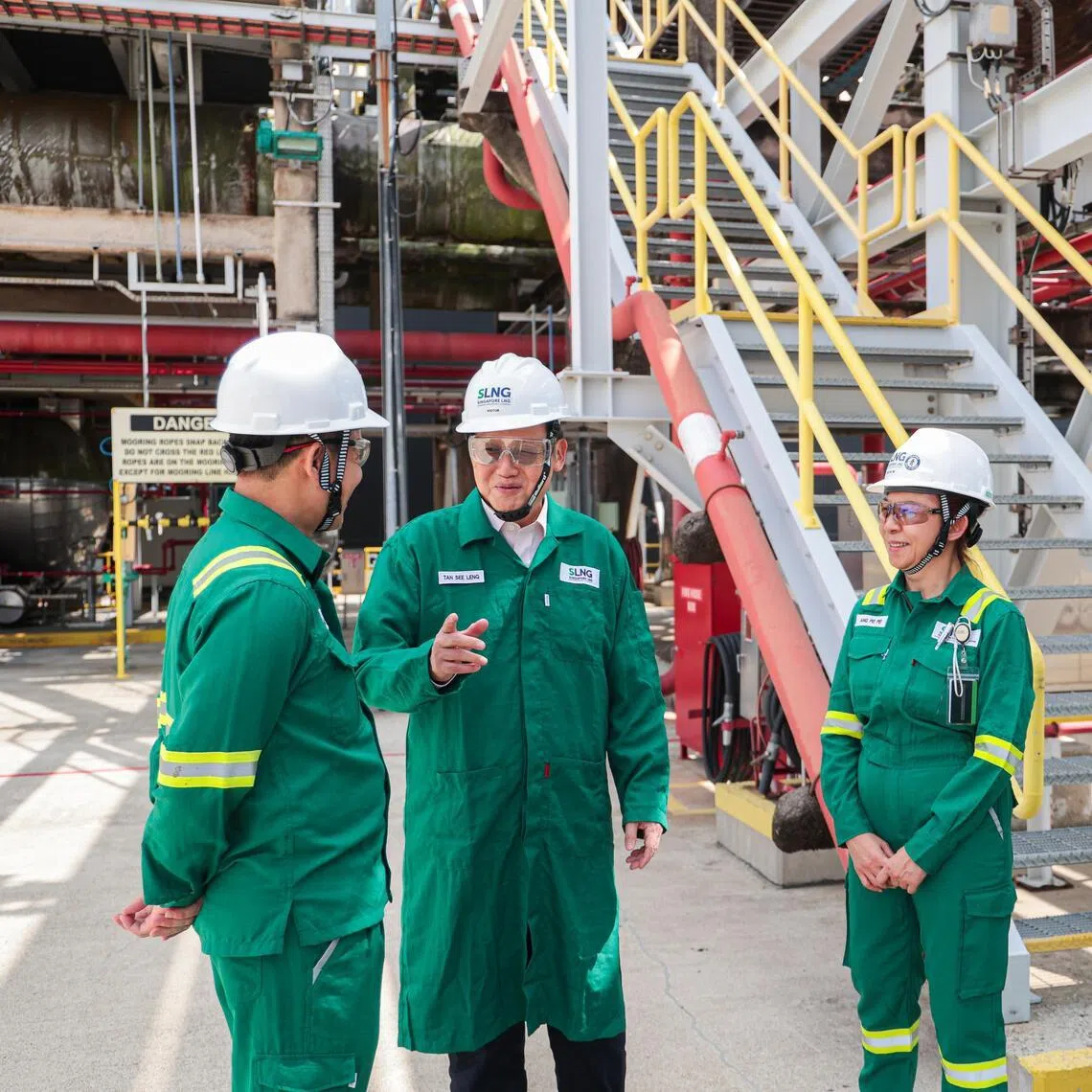 Minister-in-charge of Energy and Science & Technology Tan See Leng (second from left) speaking to workers during a visit to the SLNG Terminal on Jurong Island on March 20.