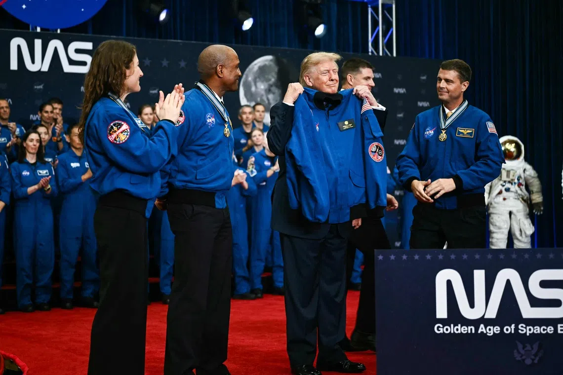 US President Donald Trump holding up a jacket given to him by the Artemis II crew members after presenting them with the Congressional Space Medal of Honor at the Lyndon B. Johnson Space Center in Houston, Texas, on Aug 28, 2026.