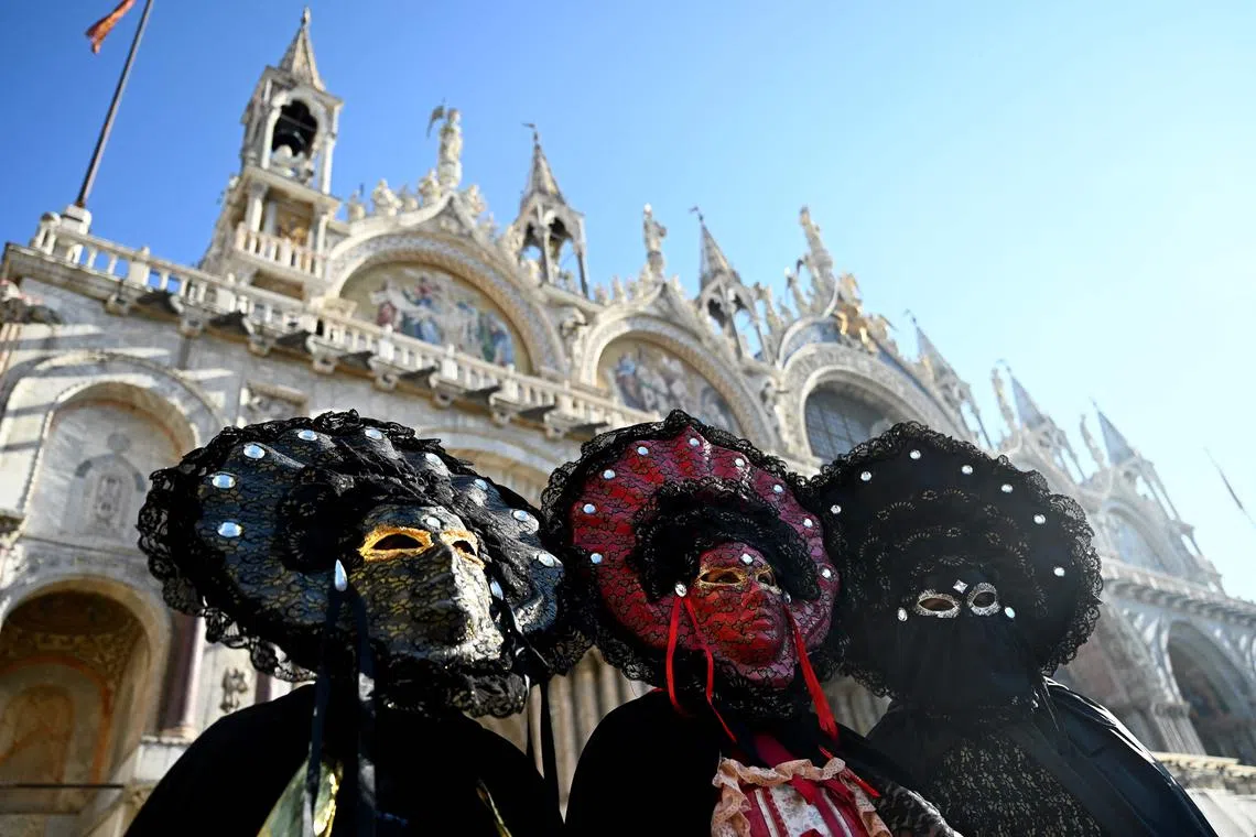 Masked revellers wearing period costumes posing at St.Mark's square during the Venice carnival on Jan 28, 2024 in Venice.