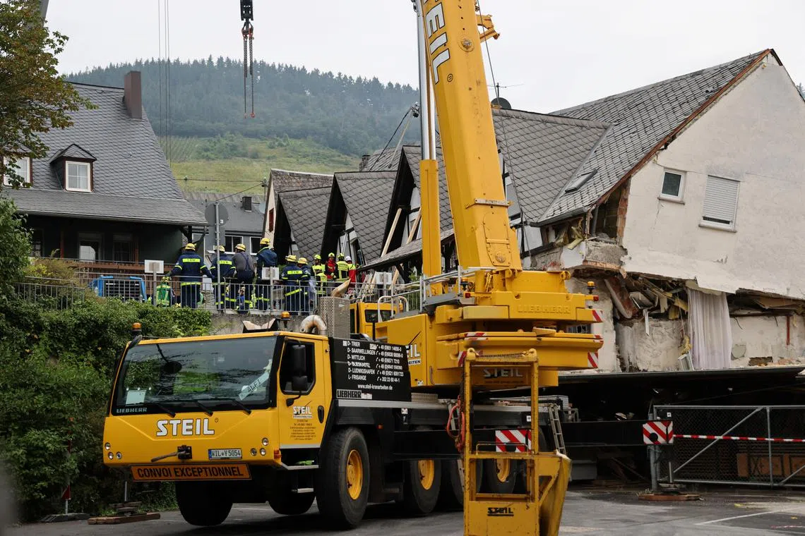 A crane is set up on Aug 7 after a hotel partially collapsed overnight near the banks of Germany's river Moselle in Kroev.