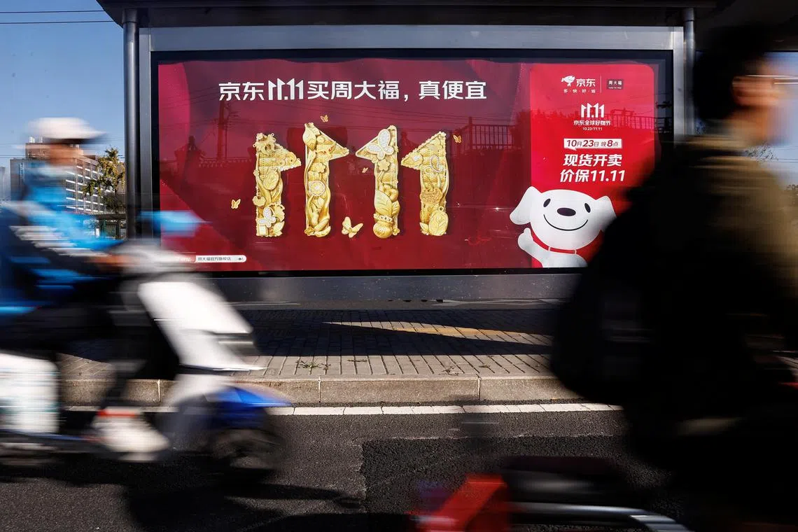 People ride on a scooter past a JD.com's advertisement promoting Singles Day shopping festival, in Beijing, China October 26, 2023. REUTERS/Tingshu Wang