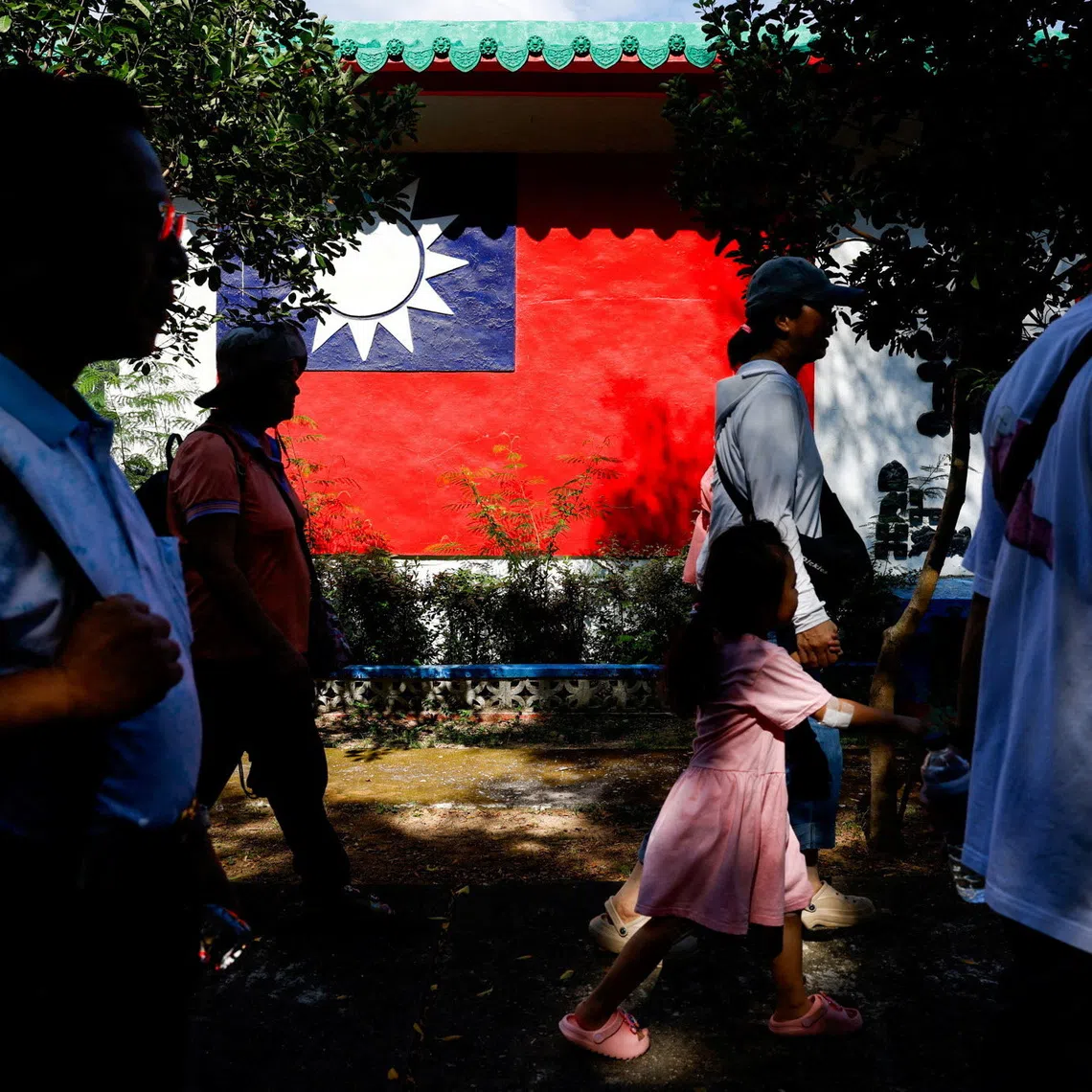 Tourists walk past a wall painted with a Taiwan flag, on Dadan Island, Kinmen, Taiwan, October 18, 2025. REUTERS/Ann Wang     TPX IMAGES OF THE DAY