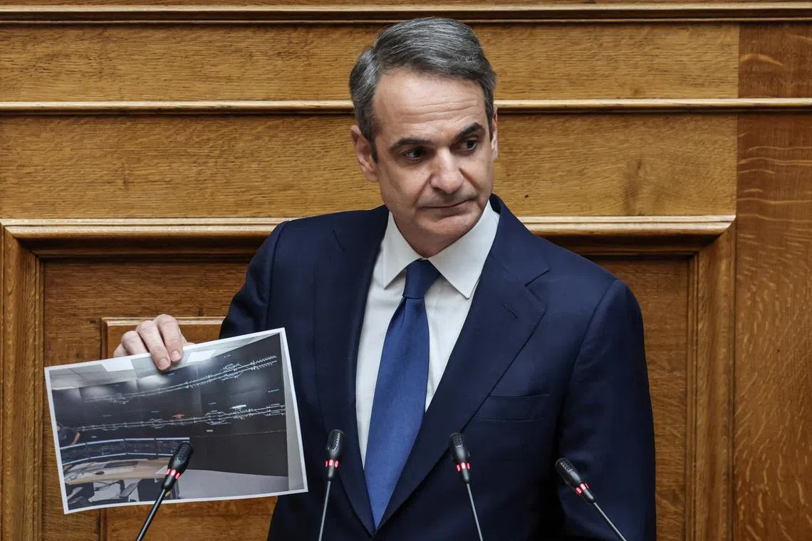 FILE PHOTO: Greek Prime Minister Kyriakos Mitsotakis shows a picture during a debate on a 2023 train crash that killed 57 people, at the Greek parliament in Athens, Greece, March 5, 2025.  REUTERS/Louisa Gouliamaki/File Photo
