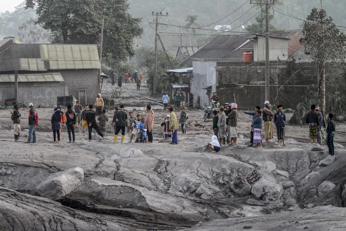 Villagers inspect the area buried in volcanic ash from the eruption of Mount Semeru at Kajar Kuning village in Lumajang, East Java, Indonesia, Dec 5, 2022. 