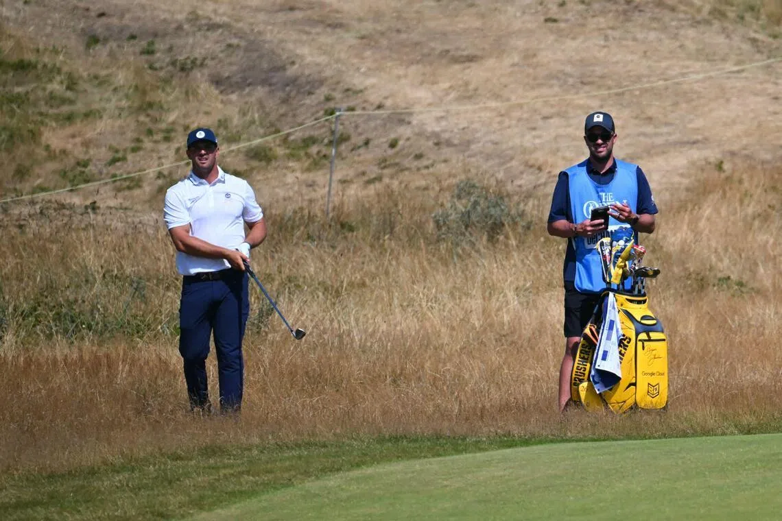 US golfer Bryson DeChambeau (left) and caddie Greg Bodine standing in the rough on the 16th hole during practice for the 154th Open Golf championship at Royal Birkdale Golf Club on July 13.