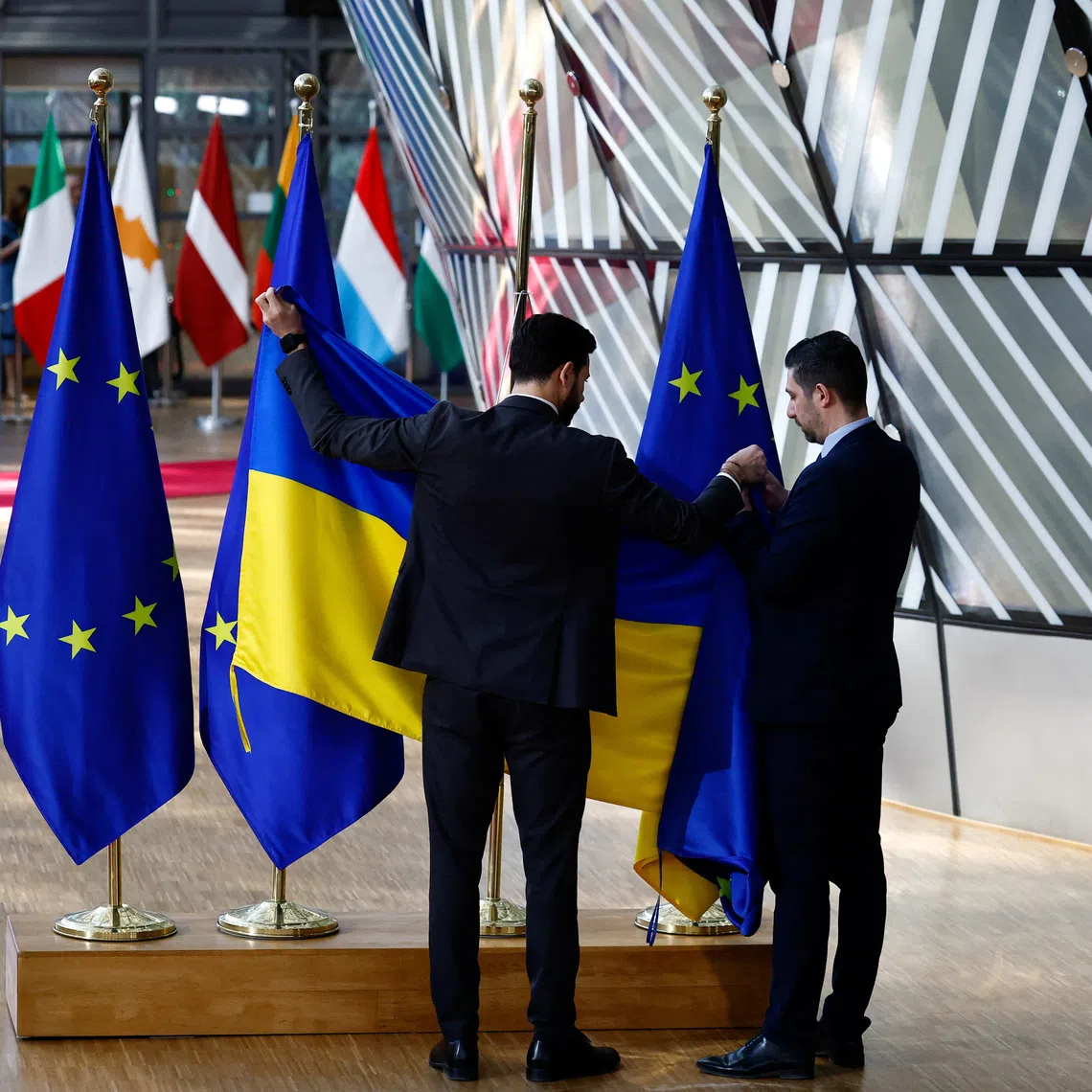 FILE PHOTO: Ushers replace an EU flag with a Ukrainian flag on the day of a European Union leaders special summit to discuss Ukraine and European defence, in Brussels, Belgium March 6, 2025. REUTERS/Stephanie Lecocq/File Photo