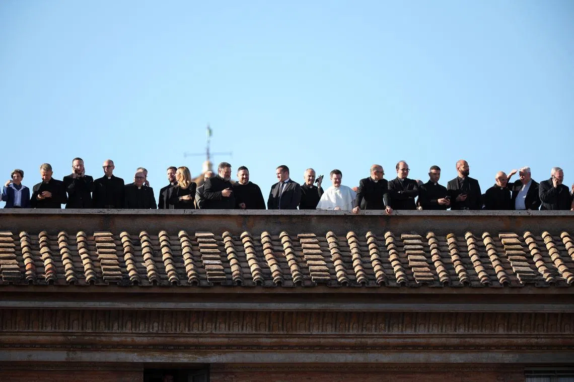 People standing on rooftops after white smoke rose from the chimney of the Sistine Chapel, signaling the election of a new pope at the Vatican on May 8.
