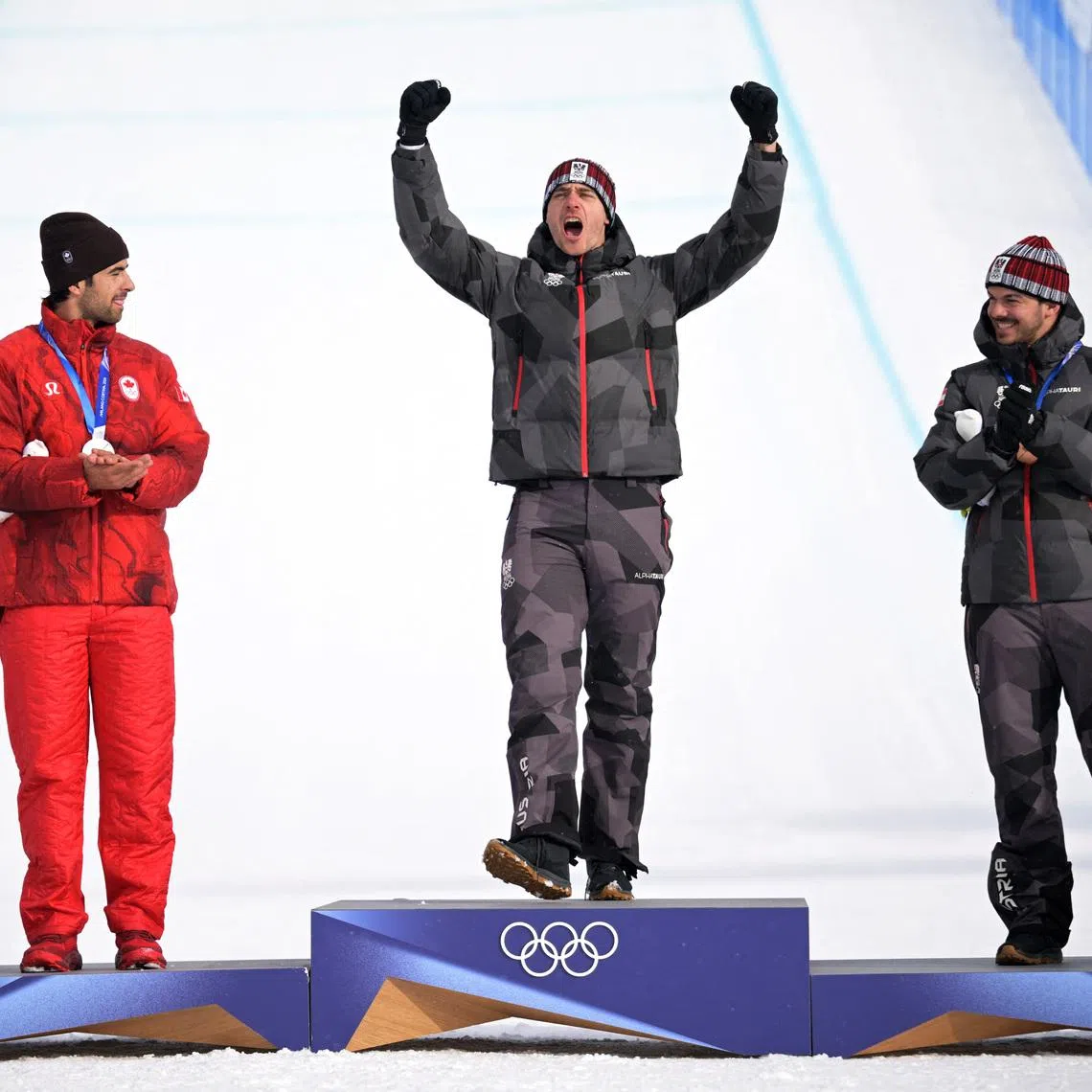 Milano Cortina 2026 Olympics - Snowboard - Men's Snowboard Cross Victory Ceremony - Livigno Snow Park, Livigno, Italy - February 12, 2026. Gold medallist Alessandro Haemmerle of Austria celebrates on the podium with silver medallist Eliot Grondin of Canada and bronze medallist Jakob Dusek of Austria REUTERS/Dylan Martinez