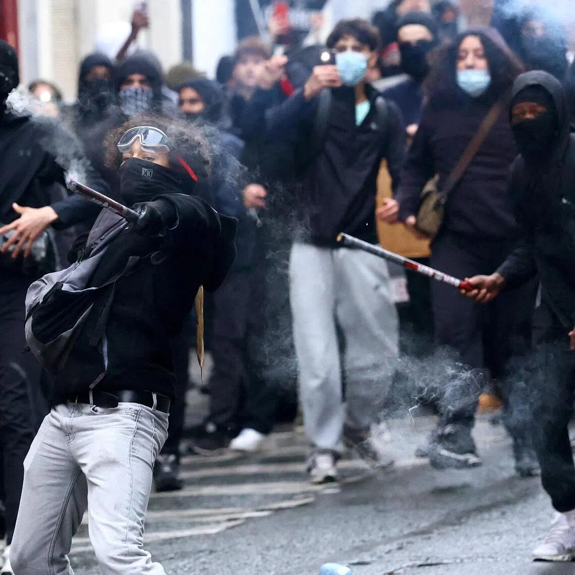 A few dozen masked protesters dressed in black threw rocks and other objects at police.