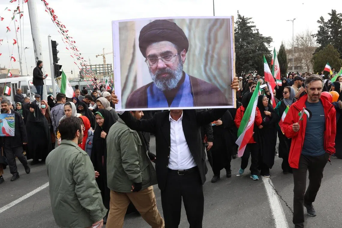 An Iranian man holds a portrait of Mojtaba Khamenei, son of the late Supreme Leader Ayatollah Ali Khamenei, during the 47th anniversary celebrations of the Islamic Revolution in Tehran on Feb 11, 2026.