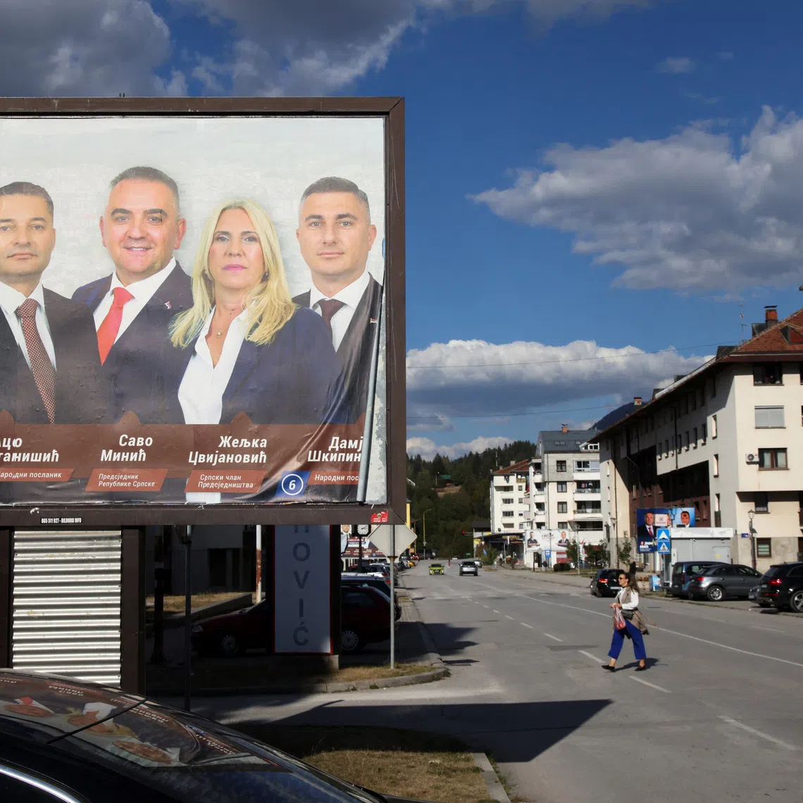 People walk past near a campaign billboard featuring Milorad Dodik, Aco Stanisic, Savo Minic, Zeljka Cvijanovic and Damjan Skipina, candidates of the Alliance of Independent Social Democrats (SNSD) in Bosnia and Herzegovina's 2026 general election, in Pale, Bosnia and Herzegovina, September 29, 2026. REUTERS/Amel Emric
