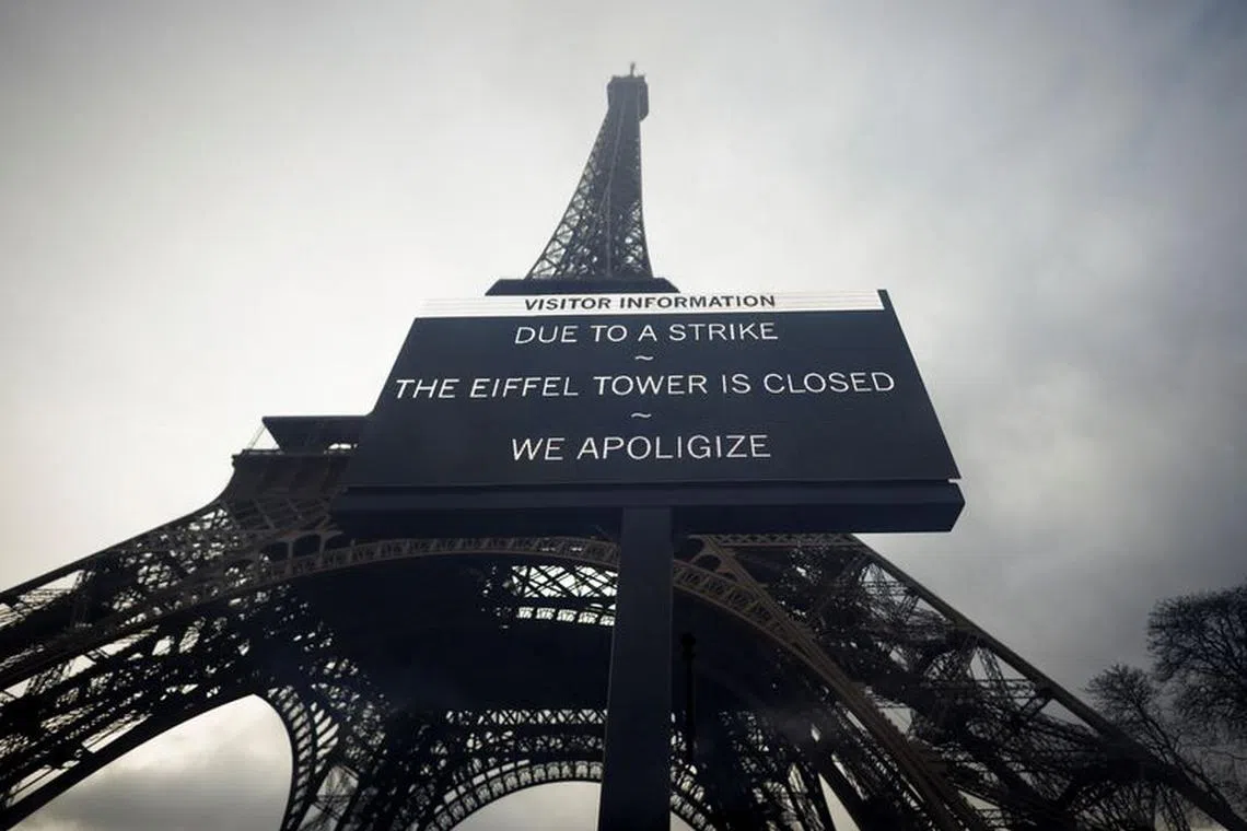 A sign reading \"Due to a strike, the Eiffel Tower is closed. We apoligize\" hangs in front of the Eiffel Tower in Paris, France, February 19, 2024. Picture taken through glass. REUTERS/Sarah Meyssonnier