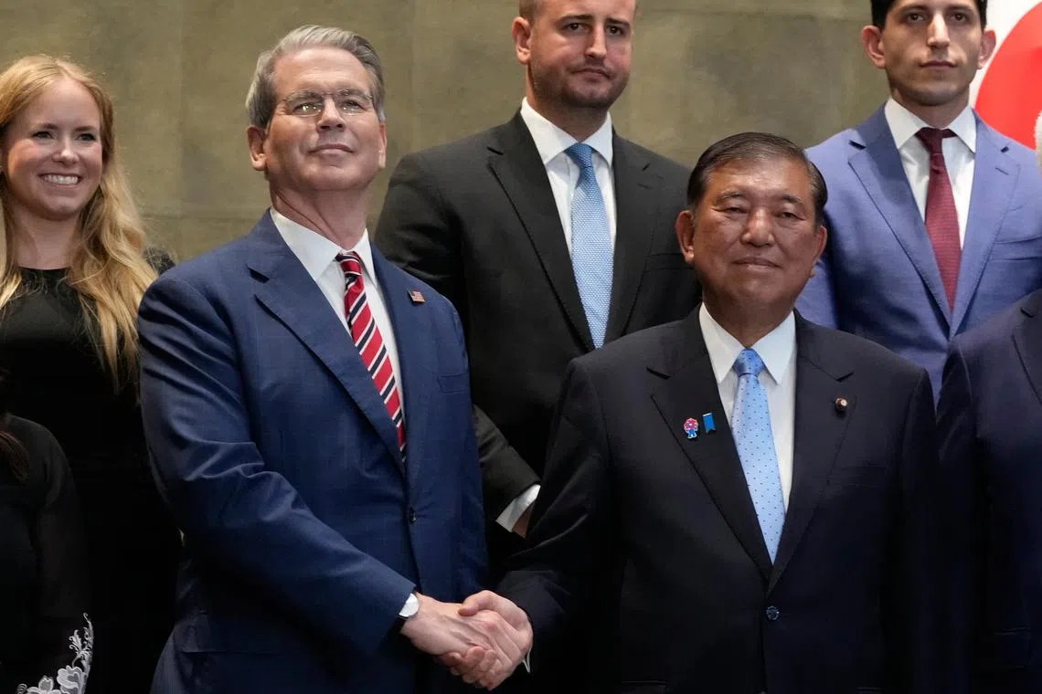 Japanese PM Shigeru Ishiba (right) shakes hands with U.S. Treasury Secretary Scott Bessent before their meeting at the prime minister's office in Tokyo on July 18.